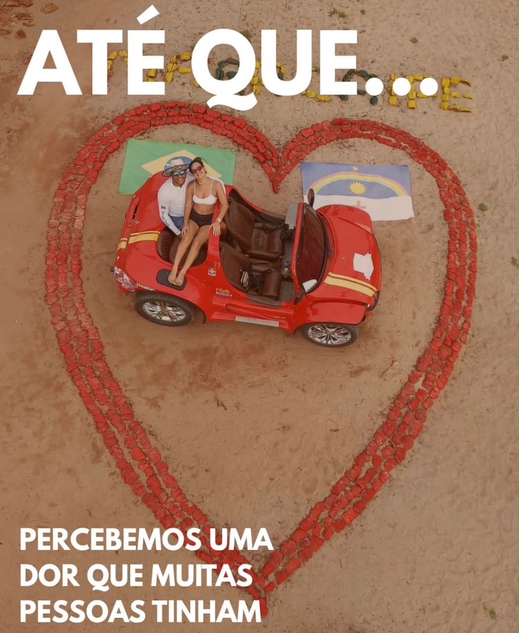 Casal em buggy dentro de um coração desenhado na areia